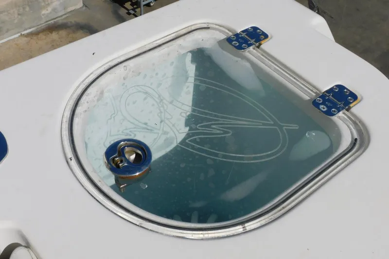 Slide: The Image of Livewell lid on a 2012 Sailfish 30-06 Express boat, featuring a clear top and blue hinges. - 6