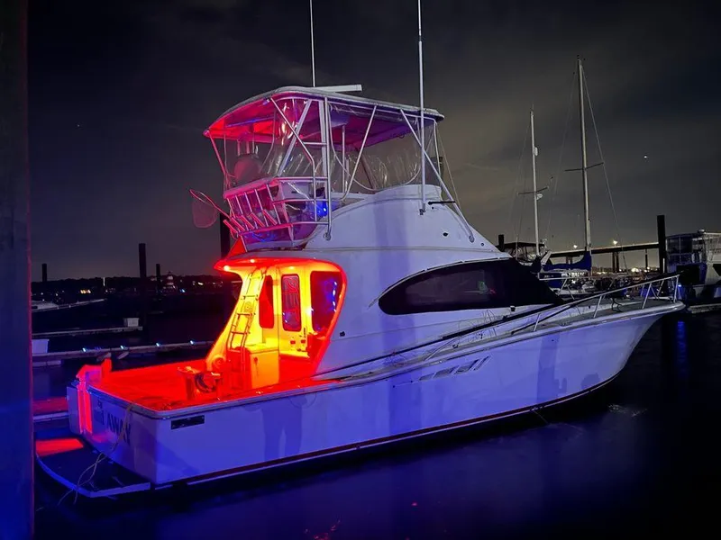 Slide: The Image of 1993 Luhrs Tournament 380 Convertible boat illuminated at night with vibrant red lights. - 1