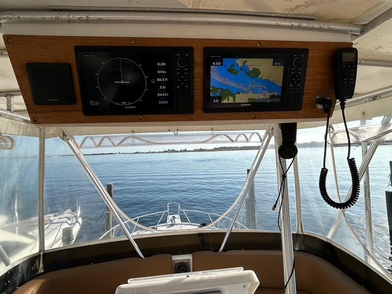 Slide: The Image of 1993 Luhrs Tournament 380 Convertible helm with navigation screens, overlooking calm waters. - 11