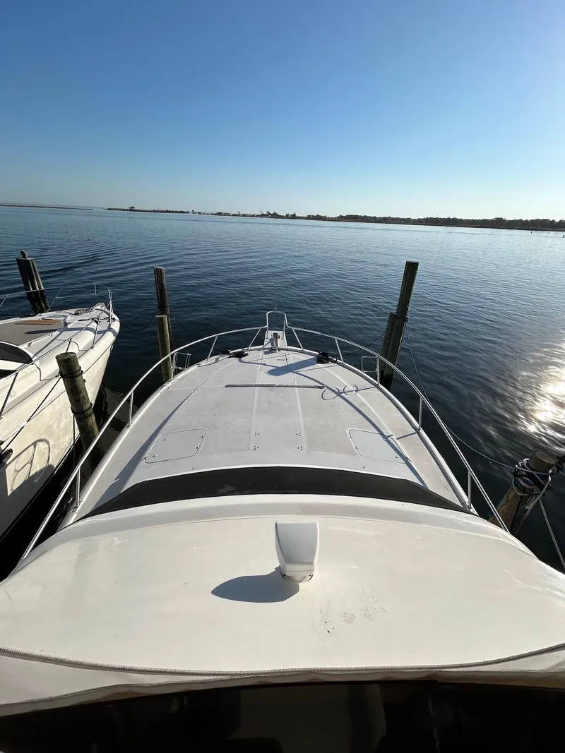 Slide: The Image of 1993 Luhrs Tournament 380 Convertible boat docked on calm water under clear blue sky. - 12