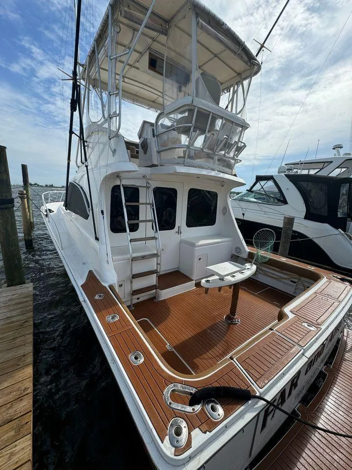 Slide: The Image of 1993 Luhrs Tournament 380 Convertible boat with spacious deck and flybridge, docked at marina. - 6