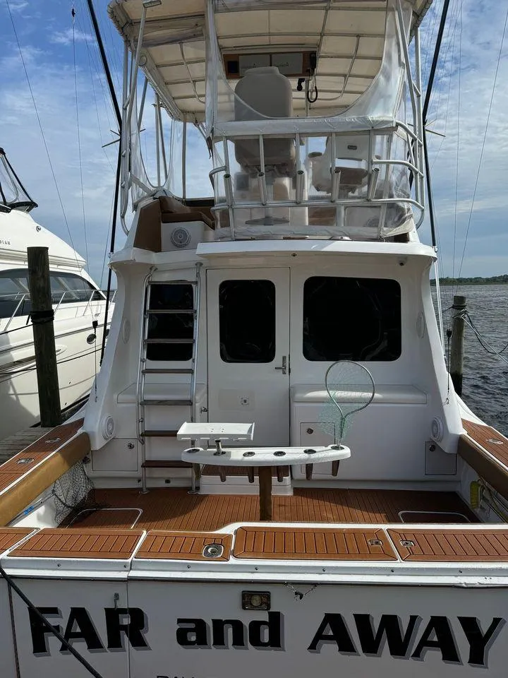 Slide: The Image of 1993 Luhrs Tournament 380 Convertible boat docked, rear view with fishing setup. - 7