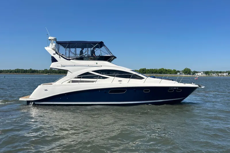 The Image of 2012 Sea Ray 450 Sedan Bridge yacht cruising on a sunny day. - 0