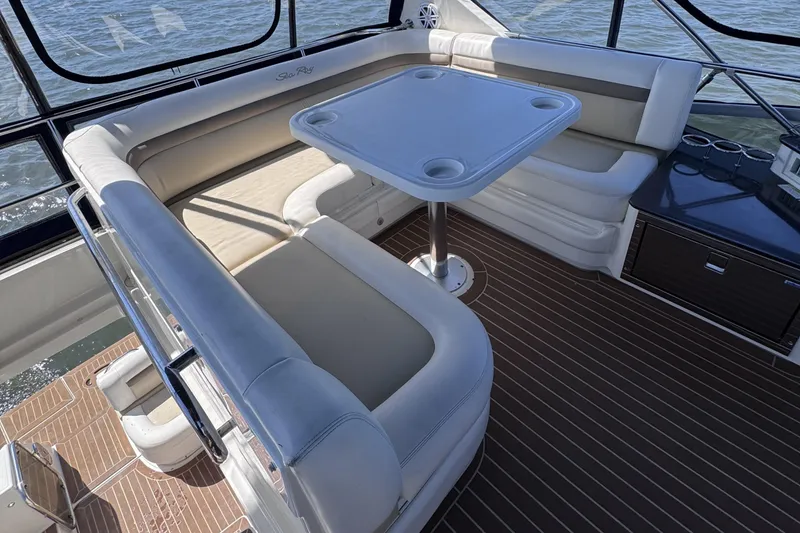 Slide: The Image of 2012 Sea Ray 450 Sedan Bridge interior with cushioned seating and table on deck. - 6