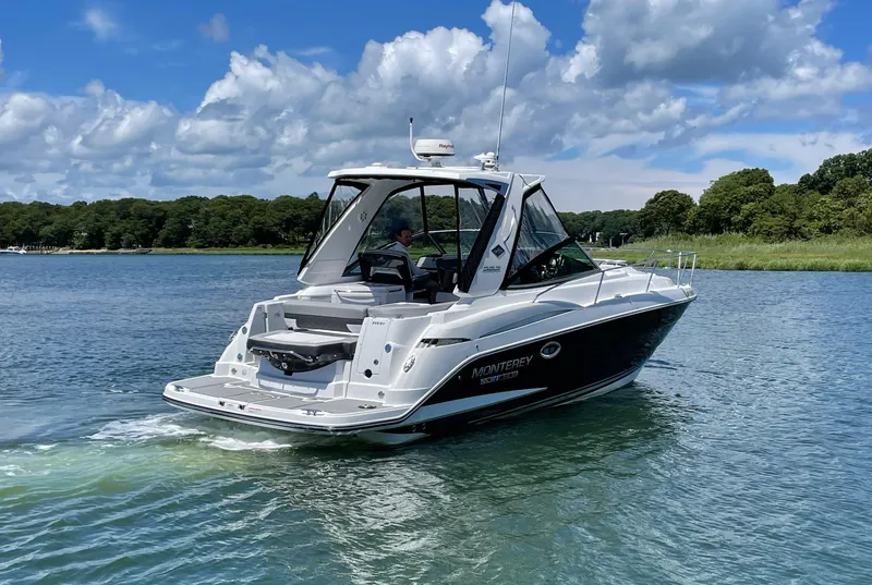 Slide: The Image of Monterey 335 Sport Yacht 2021 cruising on calm water under sunny skies. - 4