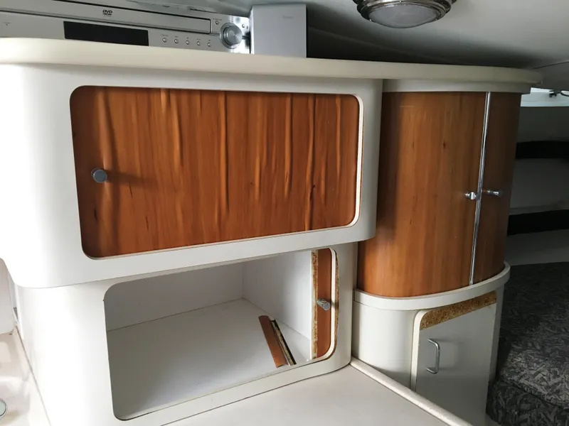 Slide: The Image of 1999 Chris-Craft 320 Express Cruiser interior with wooden cabinets. - 21