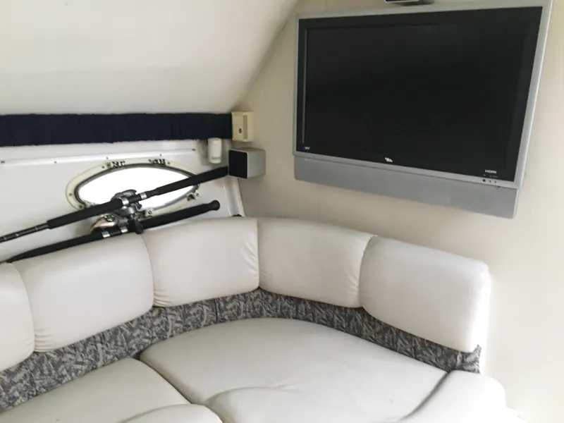 Slide: The Image of 1999 Chris-Craft 320 Express Cruiser interior with TV and seating. - 22