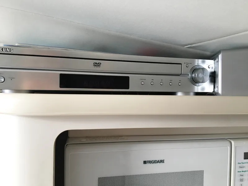 Slide: The Image of Samsung DVD player above Frigidaire microwave in Chris-Craft 320 Express Cruiser. - 28