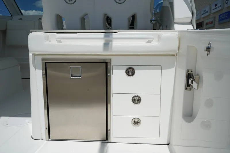 Slide: The Image of 2020 Edgewater 262CX Crossover boat interior with stainless steel storage and white seating. - 13
