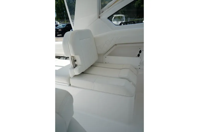 Slide: The Image of 2020 Edgewater 262CX Crossover boat interior with white seating and window view. - 19