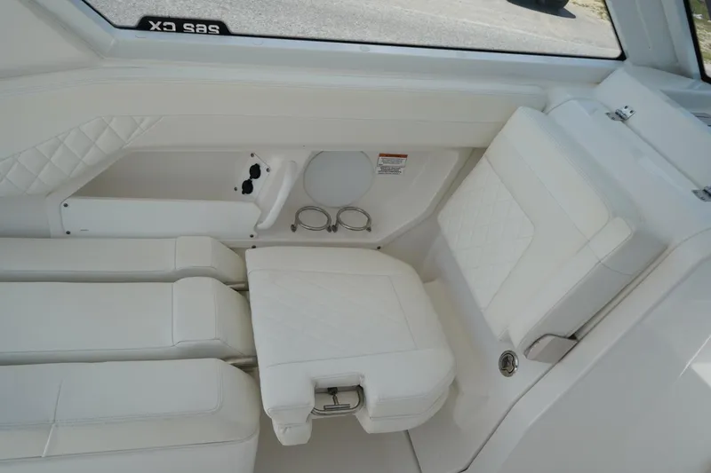 Slide: The Image of Interior of 2020 Edgewater 262CX Crossover boat with white seating and cup holders. - 20