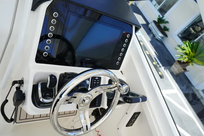 Slide: The Image of 2020 Edgewater 262CX Crossover boat dashboard with steering wheel and control panel. - 28