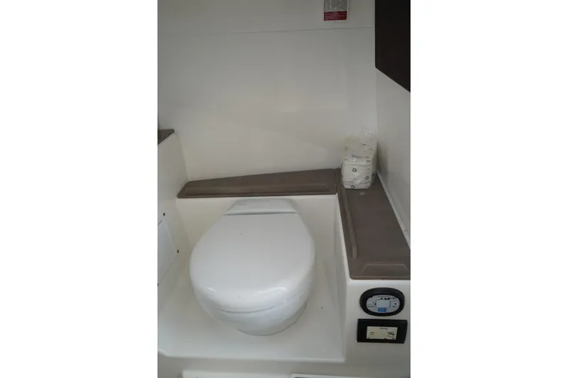 Slide: The Image of 2020 Edgewater 262CX Crossover boat interior with compact marine toilet. - 29