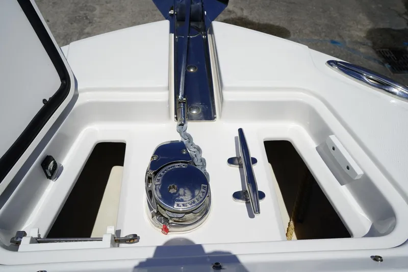 Slide: The Image of Anchor compartment of 2020 Edgewater 262CX Crossover boat, featuring a winch and cleat. - 35
