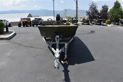 Slide: The Image of 2025 Lowe L1652MT Jon boat on trailer in parking lot, mountains in background. - 2