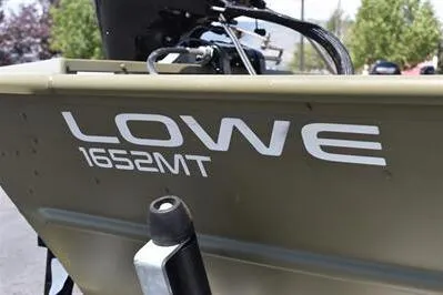 Slide: The Image of 2025 Lowe L1652MT Jon boat, close-up of model name and motor, outdoors. - 8