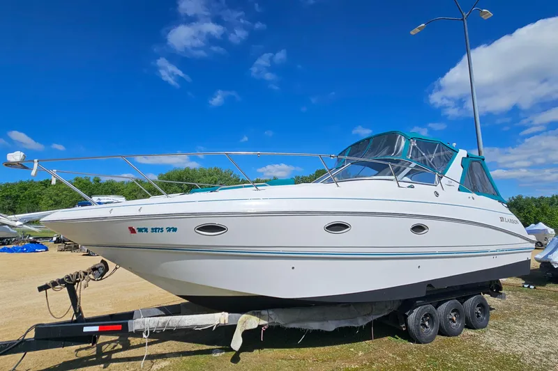 The Image of 2000 Larson Cabrio 330 boat on trailer under clear blue sky. - 1