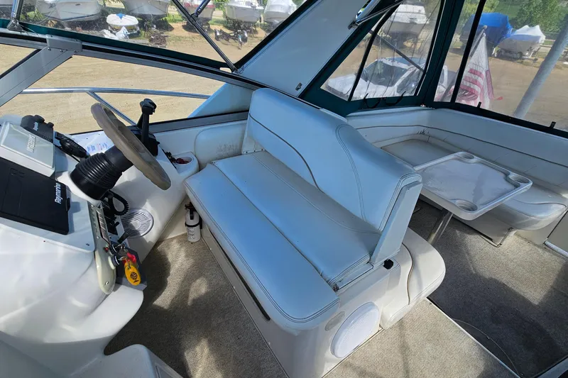 Slide: The Image of Interior of a 2000 Larson Cabrio 330 boat with helm and seating area. - 11