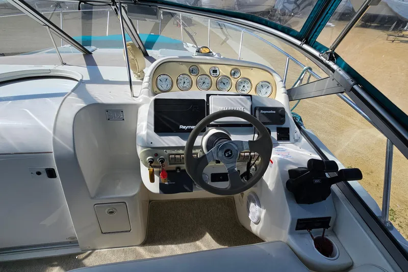 Slide: The Image of Cockpit of 2000 Larson Cabrio 330 boat with steering wheel and navigation instruments. - 12