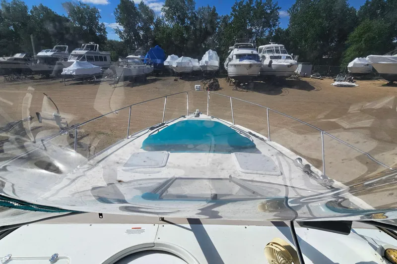 Slide: The Image of Larson Cabrio 330 boat docked, surrounded by other boats, clear sky, 2000 model. - 14
