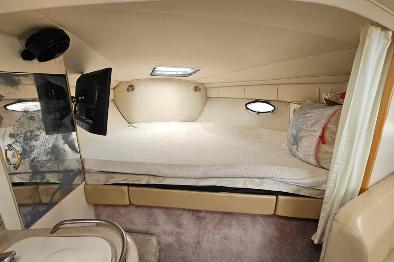 Slide: The Image of Interior cabin of 2000 Larson Cabrio 330 boat with bed, TV, and porthole window. - 17