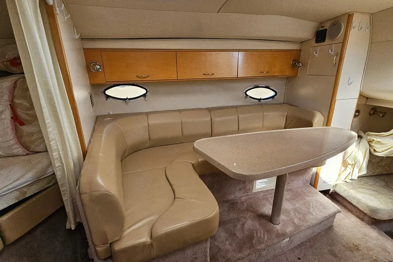 Slide: The Image of Interior of 2000 Larson Cabrio 330 boat with beige seating and table. - 18