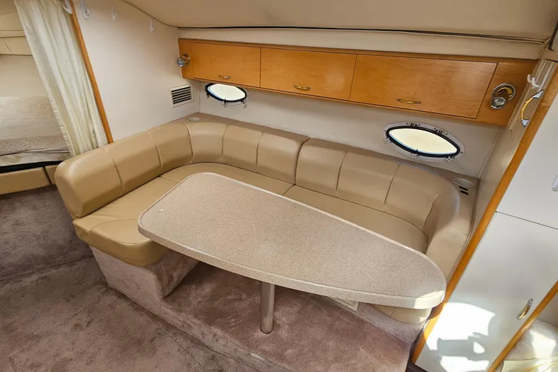 Slide: The Image of Interior of 2000 Larson Cabrio 330 boat with beige seating and wooden cabinets. - 19