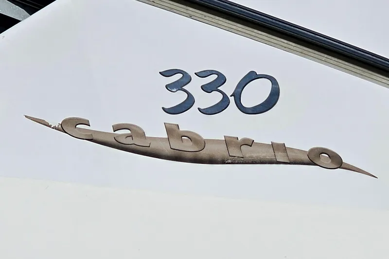 Slide: The Image of Larson Cabrio 330 boat emblem, 2000 model, featuring stylish lettering. - 27
