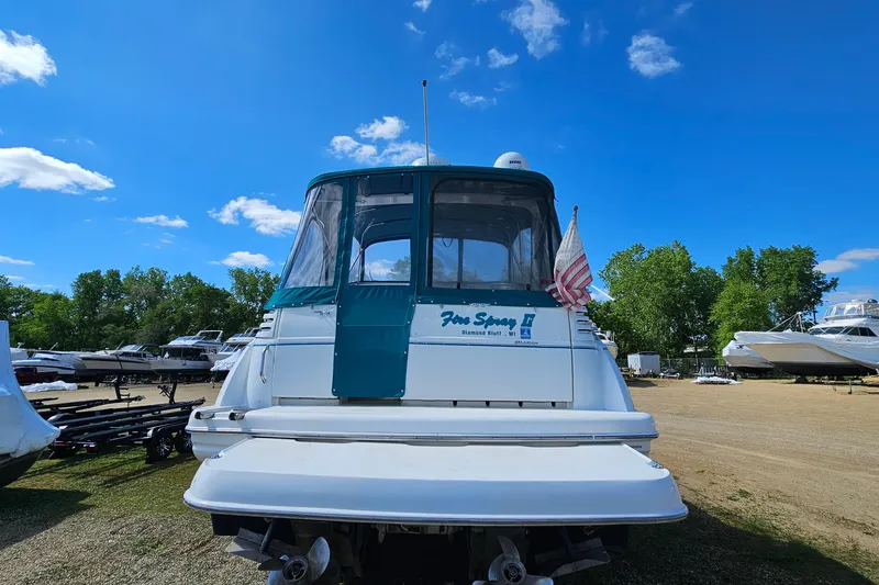 Slide: The Image of 2000 Larson Cabrio 330 boat with American flag, parked outdoors under blue sky. - 5