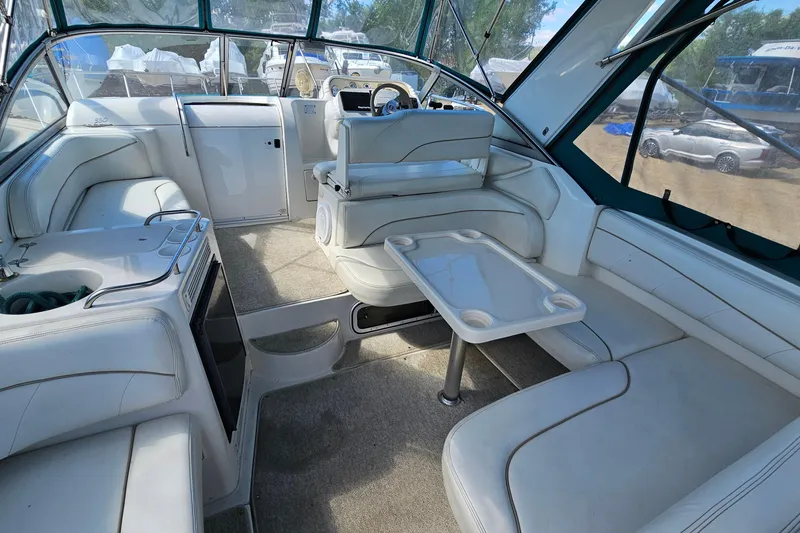 Slide: The Image of Interior of a 2000 Larson Cabrio 330 boat with white seating and a central table. - 6