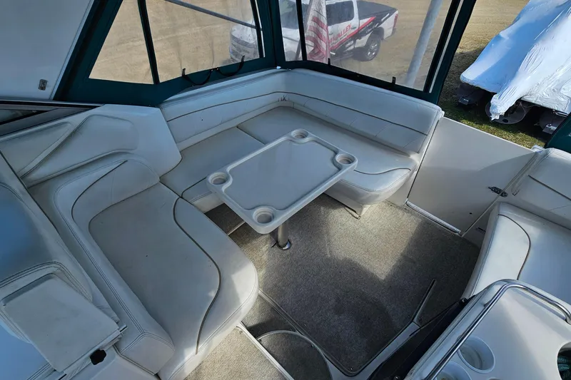 Slide: The Image of Interior of a 2000 Larson Cabrio 330 boat with white seating and table. - 8