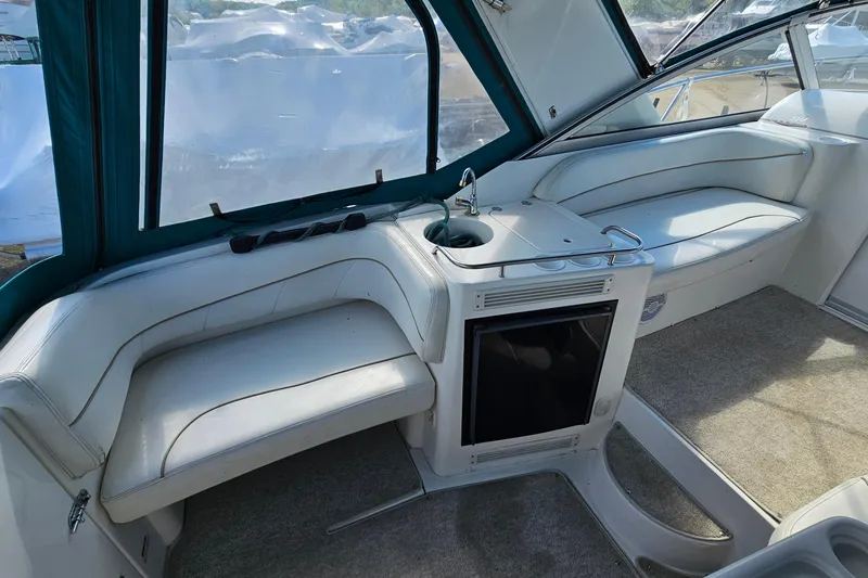 Slide: The Image of Interior of 2000 Larson Cabrio 330 boat with white seating and compact kitchenette. - 9