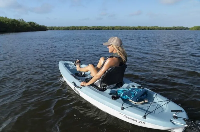 Slide: The Image of Woman kayaking on a 2023 Hobie Passport 10.5 in a serene lake. - 2