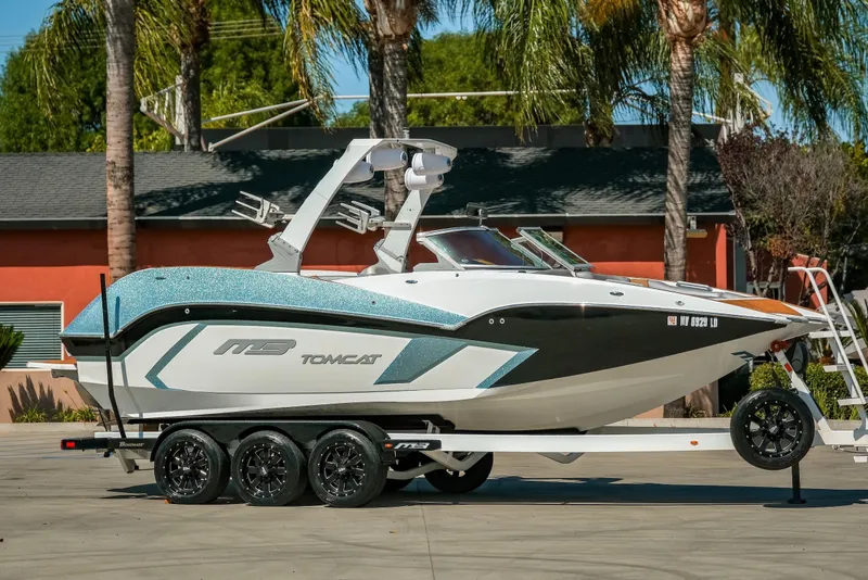 The Image of 2021 MB F24 Tomcat Alpha boat on trailer, parked outdoors with palm trees. - 1