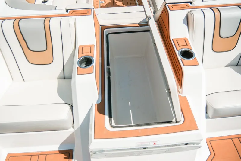 Slide: The Image of 2021 MB F24 Tomcat Alpha boat interior with open storage compartment and cup holders. - 26