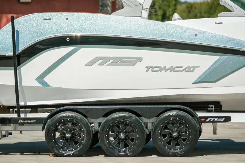 Slide: The Image of 2021 MB F24 Tomcat Alpha boat on trailer with sleek design and shiny wheels. - 6
