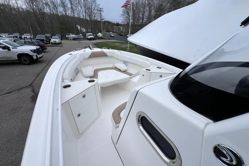 Slide: The Image of 2022 Edgewater 262CC boat interior with seating and storage, parked outdoors. - 11