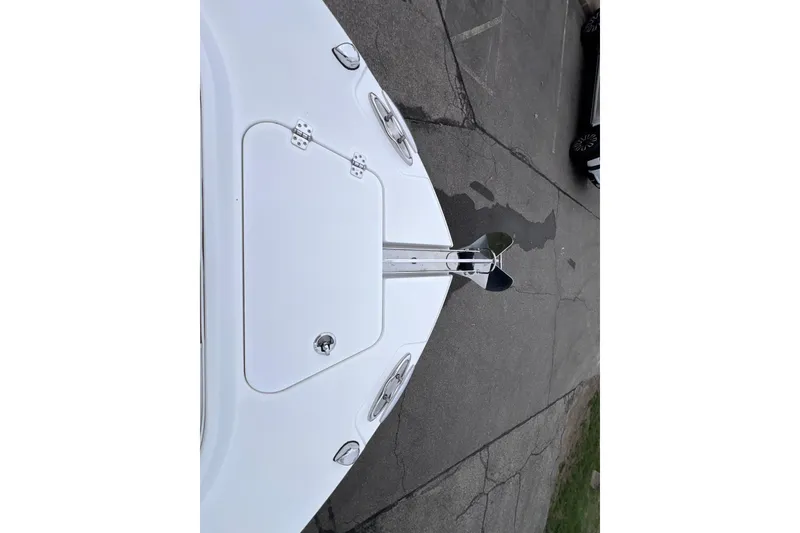 Slide: The Image of 2022 Edgewater 262CC boat bow with anchor on pavement. - 16