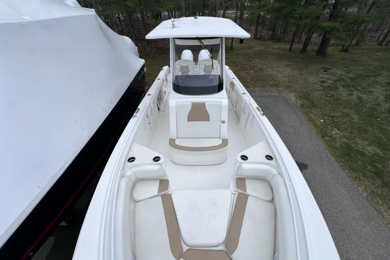 Slide: The Image of 2022 Edgewater 262CC boat with spacious seating and sleek design, parked outdoors. - 18