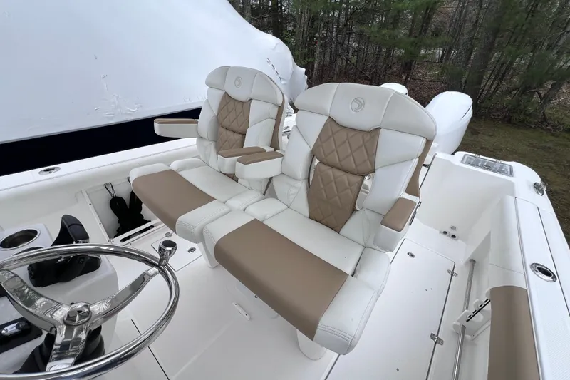 Slide: The Image of 2022 Edgewater 262CC boat interior with luxurious dual captain's chairs and steering wheel. - 19