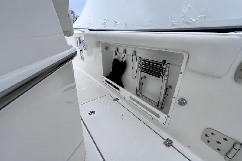 Slide: The Image of 2022 Edgewater 262CC boat interior with storage compartment and stainless steel ladder. - 20