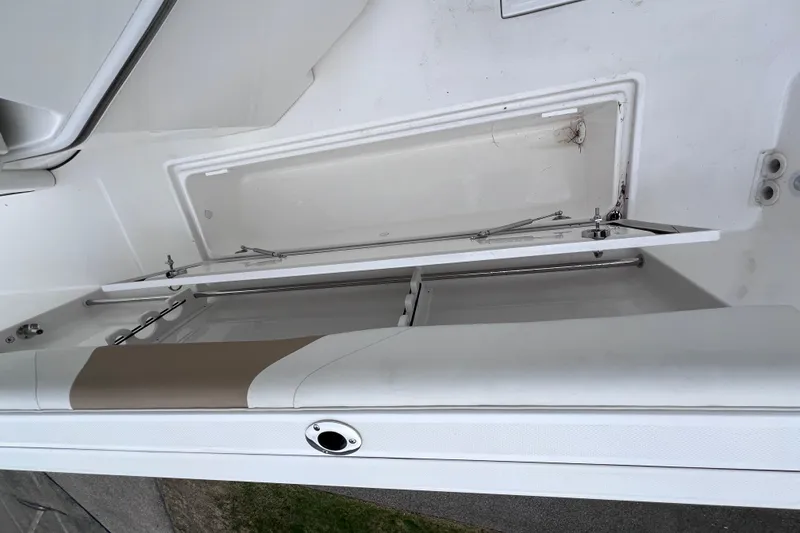Slide: The Image of Open storage compartment on a 2022 Edgewater 262CC boat, showcasing interior details. - 25