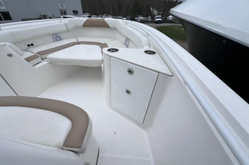Slide: The Image of 2022 Edgewater 262CC boat interior with white and beige seating and storage compartments. - 28