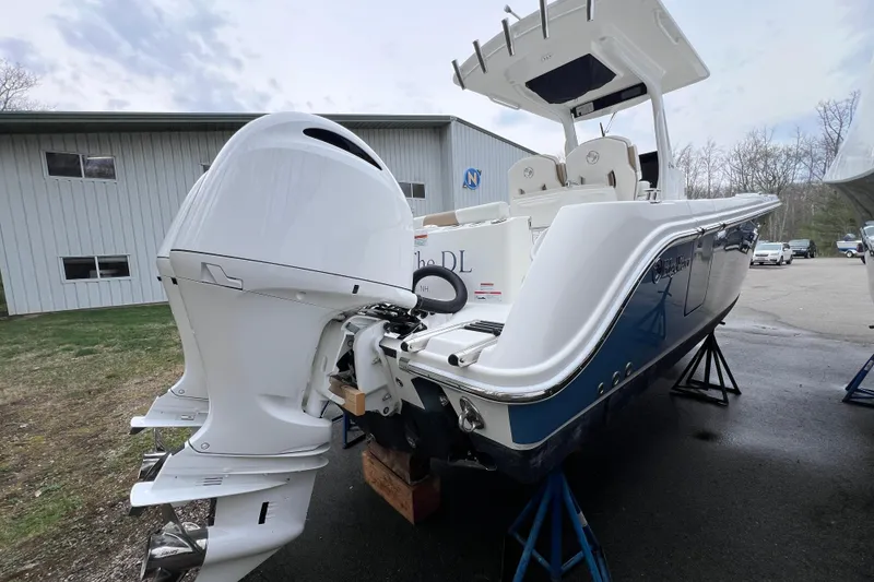 Slide: The Image of 2022 Edgewater 262CC boat with dual outboard engines on display outdoors. - 4