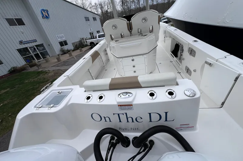 Slide: The Image of 2022 Edgewater 262CC boat docked, featuring spacious seating and storage compartments. - 8