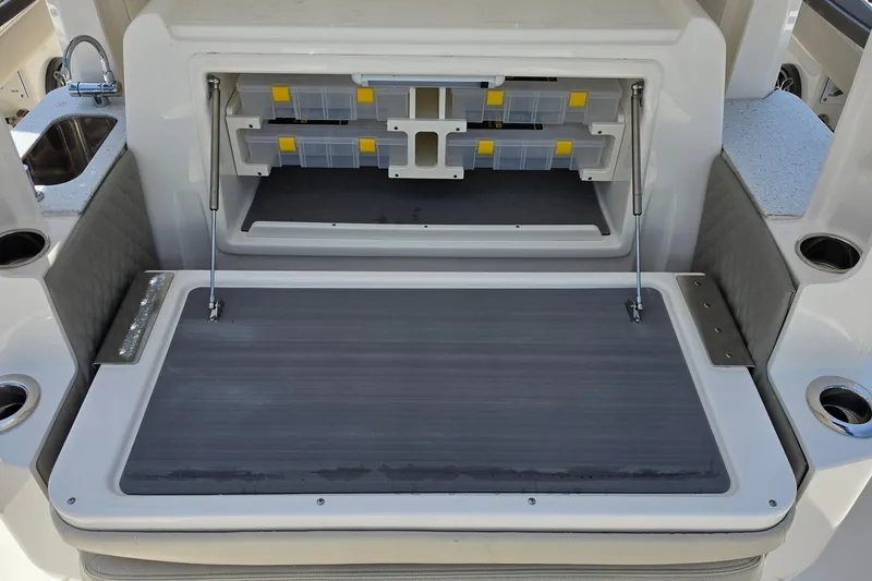 Slide: The Image of 2025 Solace 37CS boat storage compartment with tackle boxes and cup holders. - 11