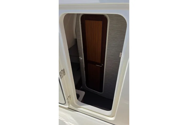 Slide: The Image of Interior cabin door of 2025 Solace 37CS boat, featuring sleek wood finish. - 26