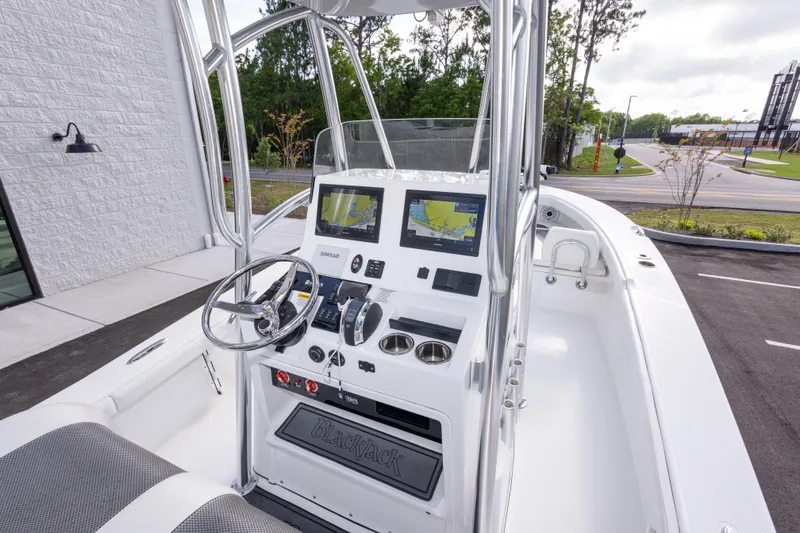 Slide: The Image of 2022 BlackJack 256 Coastal boat dashboard with navigation screens and steering wheel. - 16