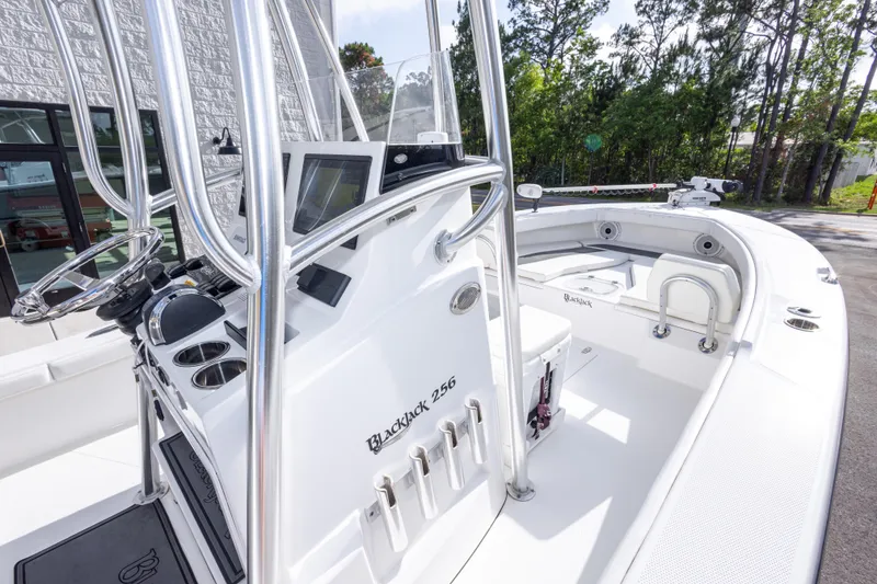 Slide: The Image of 2022 BlackJack 256 Coastal boat interior with steering console and seating area. - 18
