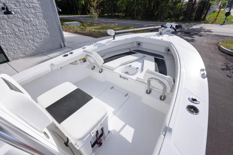 Slide: The Image of 2022 BlackJack 256 Coastal boat interior with seating and storage, parked outdoors. - 19